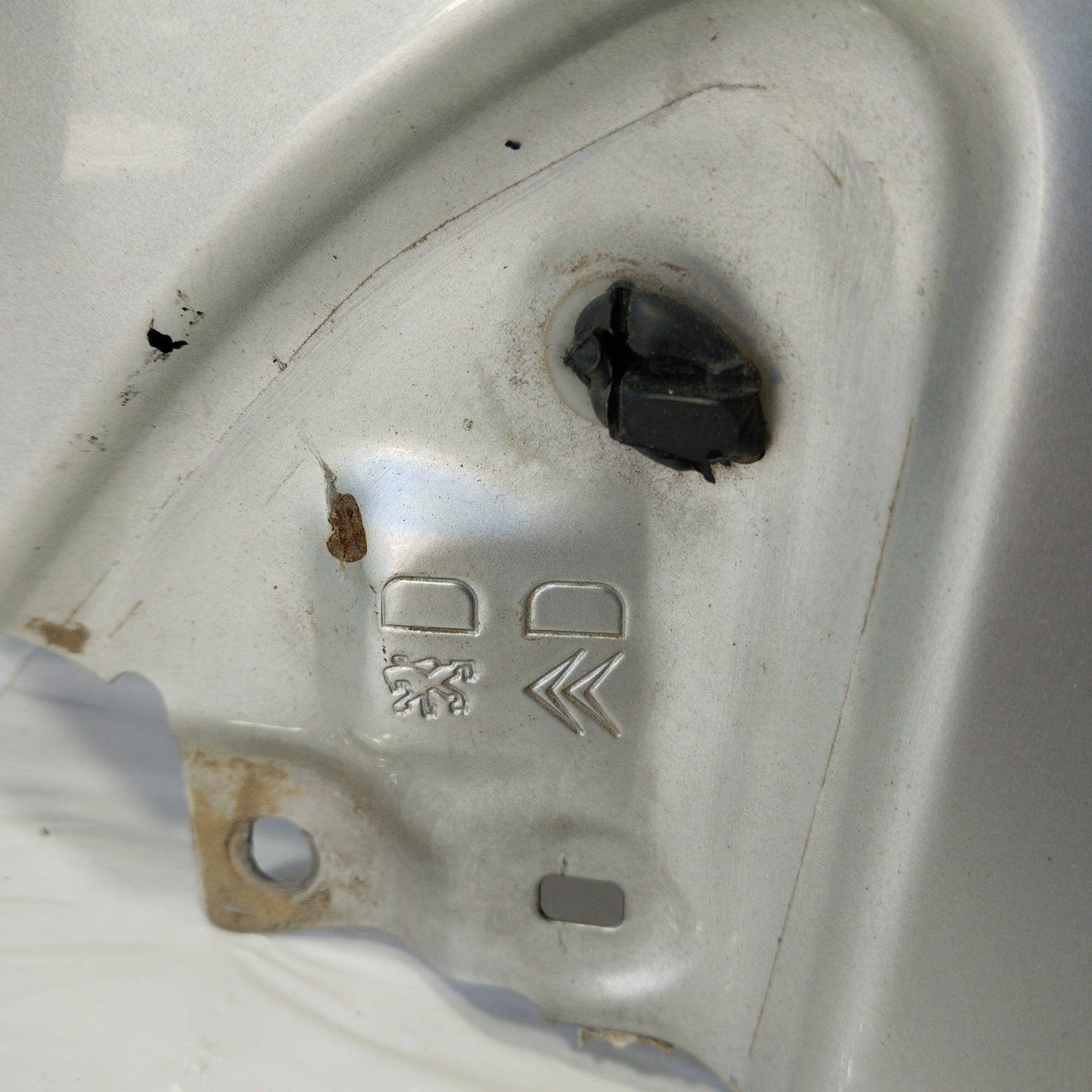 Weißer rechter Kotflügel eines Fiat Doblo 2006 weist tiefe Kratzer auf (ecoac4420).