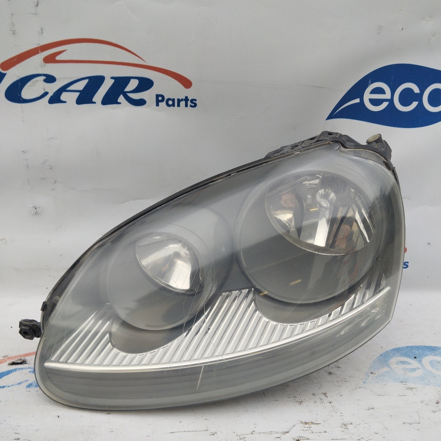 Volkswagen Golf V linker Frontscheinwerfer, grauer Hintergrund ecoAG3621