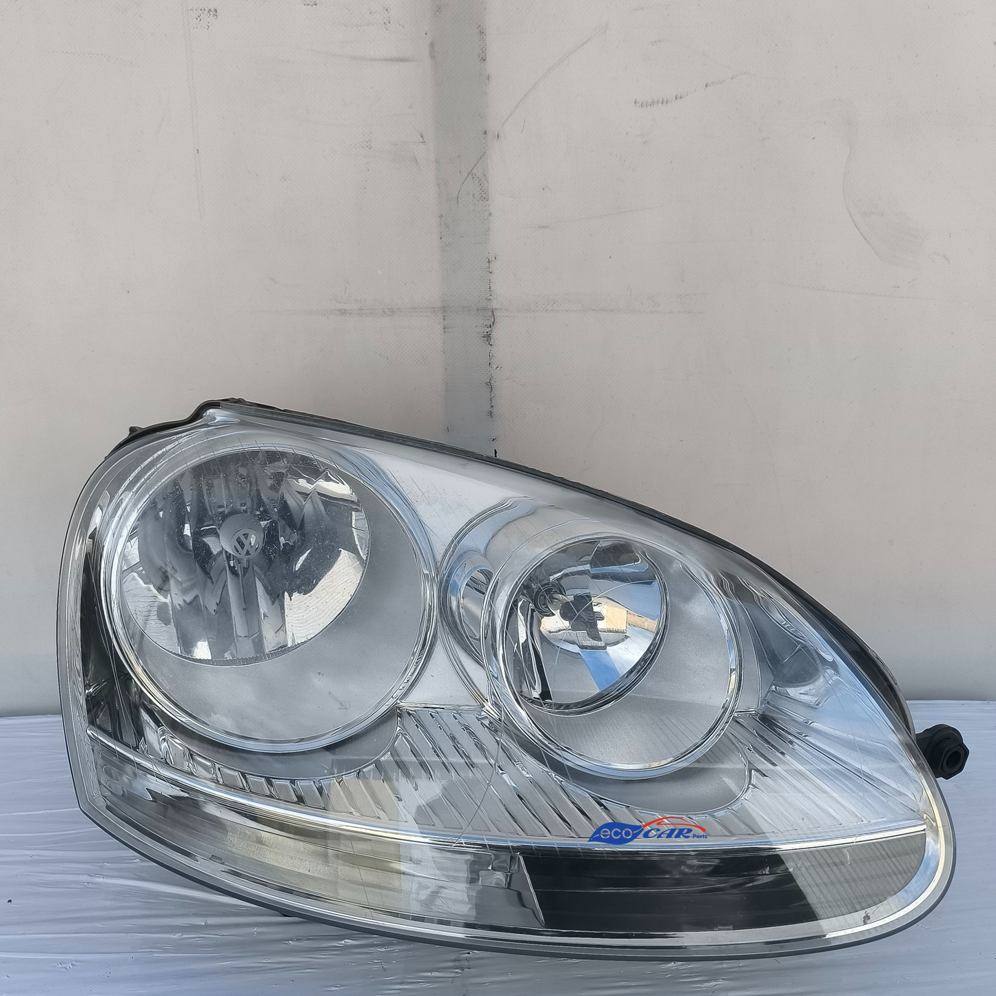 Der rechte Frontscheinwerfer des Volkswagen Golf 5 weist diverse Mikrokratzer auf (ecoAG7598).